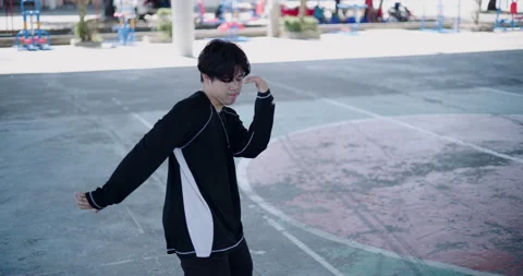Young Asian man is dancing freestyle under a dome in the park. Video stock 313121346