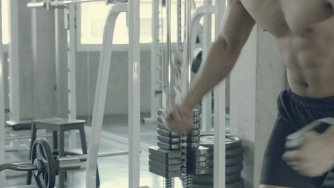 Young asian man doing cable rope triceps pull up exercise for bodybuilding in Stock Footage 121579369