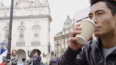 Young asian man drinking from a coffee cup in the city, in slow motion Stock-Footage 90353612