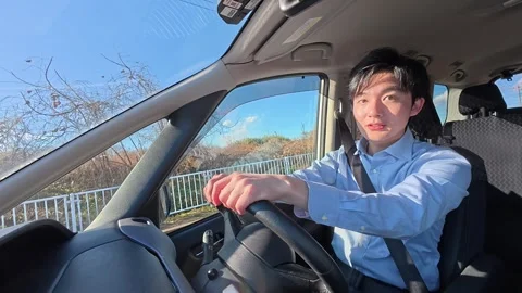 Young Asian Man Driving a Car on a Sunny Day Stock-Footage 344101344