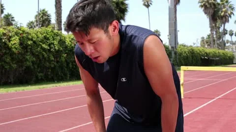 Young Asian Man Exercising Trying to Catch His Breath after a Run Stock Footage 16483277