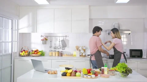 Young asian man happy help his girlfriend cook in kitchen with happiness  Video stock 147370132