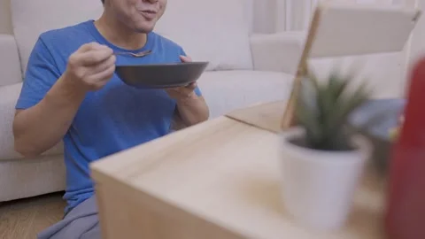 Young Asian man having fun watching comedy program on the tablet Video stock 139572428