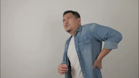 Young Asian man having lower back pain Stock Footage 143764191
