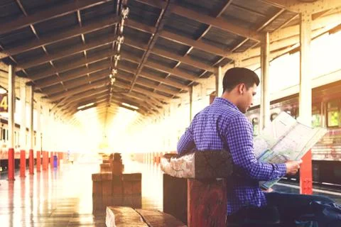 Young asian man looking map information for planning travel in summer. Stock Photos