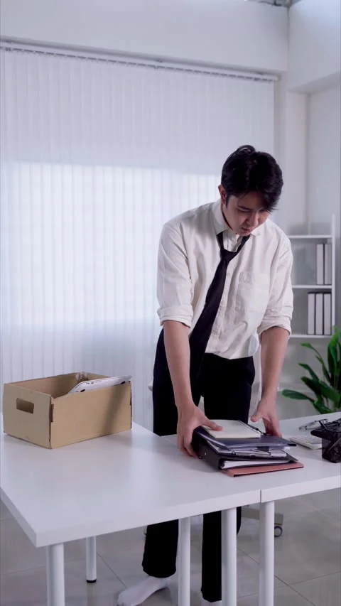 Young Asian man packing personal belongings into box while leaving corporat.. Stock Footage 345197875