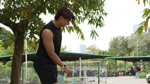 Young Asian Man Performs Balancing Exercise at Outdoor Gym in Thailand Stock Footage 335436875