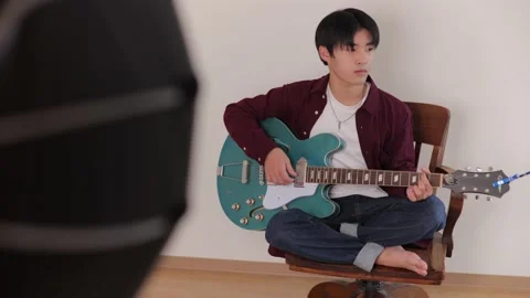 Young asian man playing archtop guitar at photo studio. Stock Footage 220759308