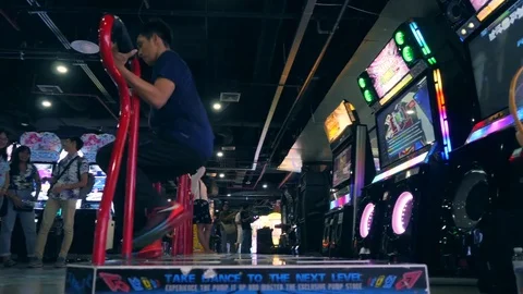 Young Asian Man Playing Dance Revolution Game and Doing Dancing Tricks on Arcade Vidéo 82340299