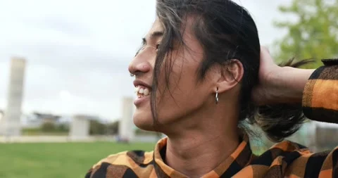 Young asian man posing in front of camera at city park Stock Footage 192384402