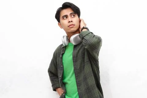 Young Asian man posing thinking about something and scratching his head sho.. Stock Photos