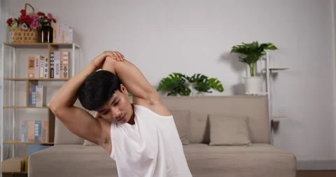 Young asian man practicing pilates in living room for a workout.  Stockbeeldmateriaal 201580293