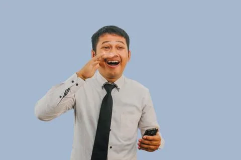 Young Asian man shouting to front with excited face expression and handheld.. Stock Photos