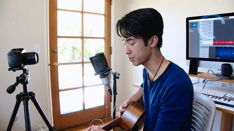 Young Asian Man Singing into Microphone with DSLR Camera Stock Footage 112638488