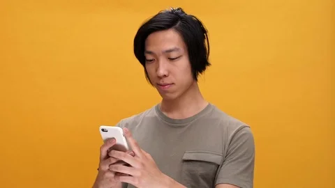 Young asian man smiling chatting by phone Stock Footage