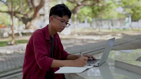 Young Asian man smiling while using laptop Stock Footage 276694837