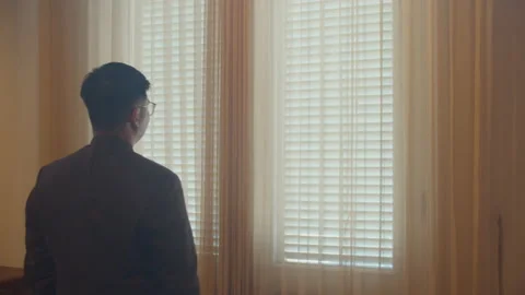 Young Asian Man Standing and Looking at The Window Stock Footage 161613784