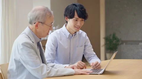 Young Asian man teaching operation of PC for a senior man. Stock Footage 163885988