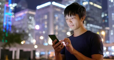 Young Asian man use of mobile phone at night Stock Footage 88859823