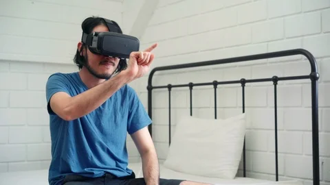 Young Asian man using glasses virtual reality simulator playing video game. Stock Footage 116916727