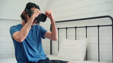Young Asian man using glasses virtual reality simulator playing boxing game. Stock Footage 116916904