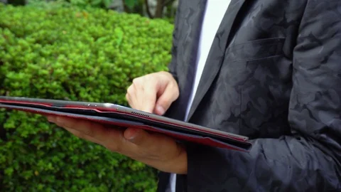 Young Asian Man Using Large Tablet Outdoors Stock Footage 104997845