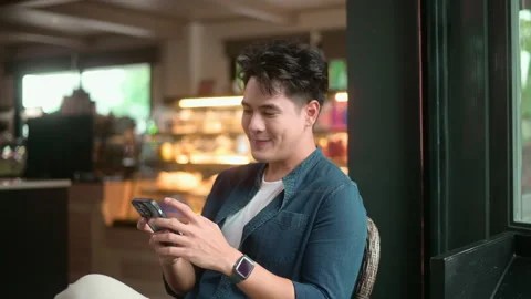 Young Asian man using smart phone in cafe Stock Footage 259037575