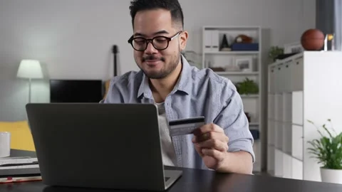 Young Asian man using smartphone holding credit card for online shopping Stock Footage 167941111