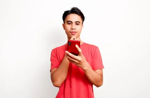 Young Asian man using smartphone looking up showing thinking gesture isolat.. Stock Photos