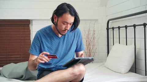 Young Asian man using tablet and credit card shopping ecommerce. Stock Footage 110744344