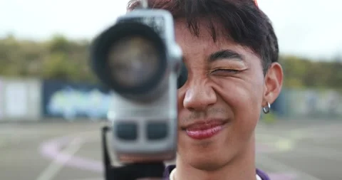 Young asian man using vintage old video camera outdoor Stock Footage 185514828