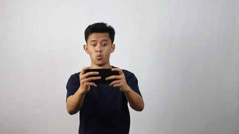 Young asian man very surprised while playing game Stock Footage 314935687