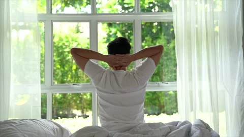 Young Asian man waking up and stretching his arms in the morning. Video stock 156638951