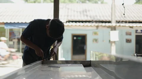 Young asian man welding two metals together and smiling to the camera Stock Footage 232586033
