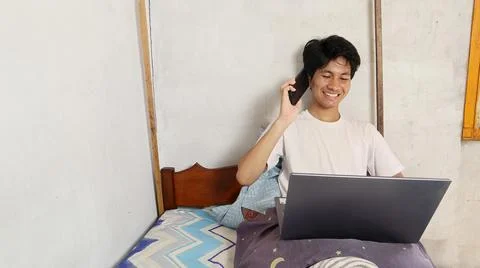 Young asian men playing, using, watching, video calling, discussing using a.. 写真素材