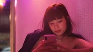 Young Asian Millennial Woman Using Smartphone In Nightclub Bar, Neon Light Stock Footage