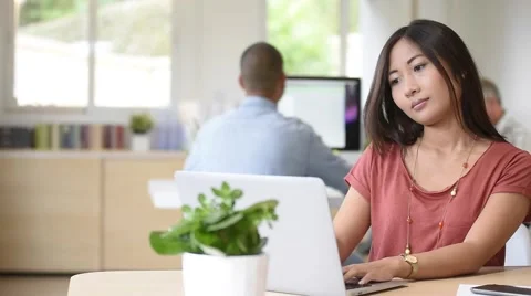 Young asian mixed-race woman working in office Stock Footage