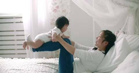 Young Asian mother with her 6 month old baby, slow motion Stock-Footage 59195651