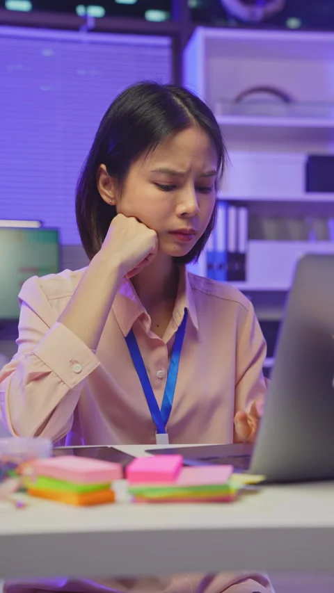 Young Asian office worker feeling overwhelmed with paperwork and workload 動画素材 336843073