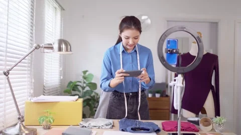Young Asian online merchant preparing products and checking phone while liv.. Stock Footage 341509571