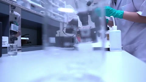 Young asian scientist looking through a microscope in a laboratory Stock Footage 196964328