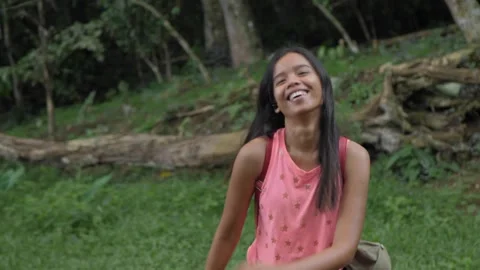 Young Asian Smiling and Dancing In The Jungle, Around Green Trees, Palm Trees Stock Footage 246610798
