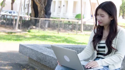 Young Asian Student Having a Video Call on Campus Outdoors Stock Footage 334165211