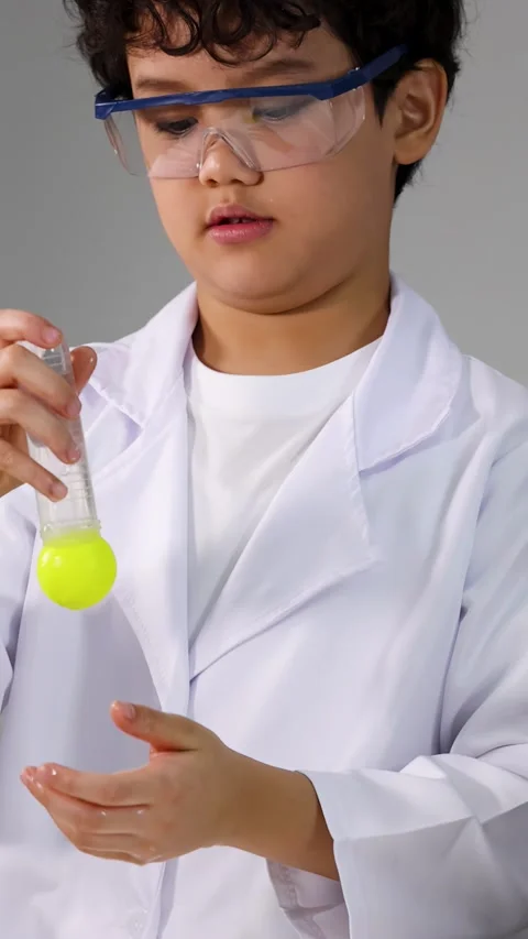Young Asian Student in Lab Coat Examining Yellow Liquid in Test Tube Stock Footage 338154970