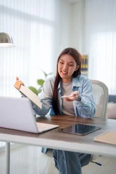 Young Asian student presenting project notes to laptop during online learni.. Stock Photos