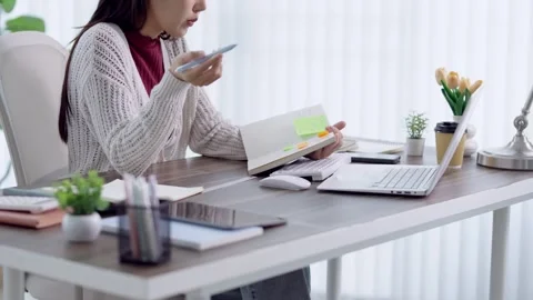 Young Asian student reviewing documents and notes while studying with lapto.. Stock Footage 341682755