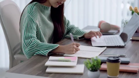 Young Asian student writing notes from laptop during online learning sessio.. Stock Footage 341682802