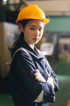 Young Asian Thai Worker, Engineer woman in heavy industry arm folded smart .. Stock Photos