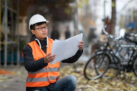 Young Asian trainee engineer at work on construction site Stock Photos