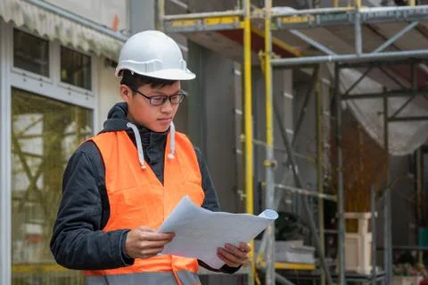 Young Asian trainee engineer at work on construction site Stock Photos